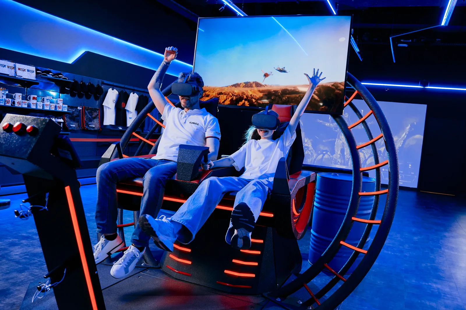 Әке мен қызы қолдарын көтеріп сақина тәрізді VR-аттракционда, экранда ұшу сахнасы